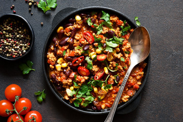 Chili con carne classic mexican dish on the kitchen table, top view.