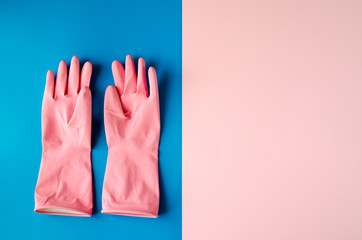 Pink cleaning gloves on coloful background