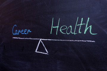 Obraz premium The concept of balance between career and work. Words on the scales on a background of chalk boards