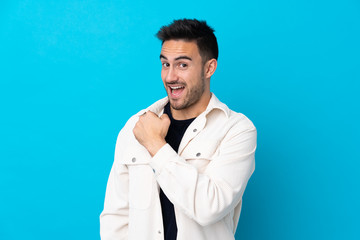 Young handsome man over isolated blue background celebrating a victory