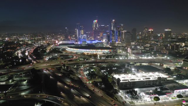 Los Angeles. Downtown. 2019. Aerial footage of the impressive night view of the huge contemporary city. Bright urban illumination of the modern highrises and multi-level road junction network. 4K