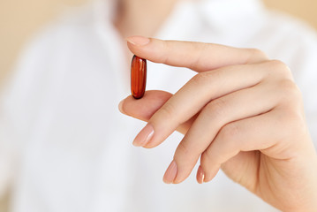 Young Women holding Medicine capsule in a hand on white background.Concept for Healthcare.