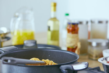 Pasta rolled on fork over pan on stove in the kitchen