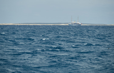 The landscape of the balearic sea, azure water, sunny weather, is a lonely sail boat is on the horizon