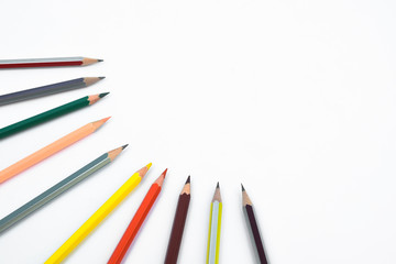 Bunch of different colored pencil crayon arranged in a circle shape all pointing the middle