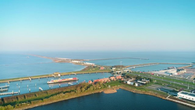 Enclosure Dam (Afsluitdijk): Large Cargo Ship Approaching the Enclosure Dam, Bridge Opening by Turning the Road 180 Degrees - Friesland, Netherlands / Holland &ndash; 4K Drone Footage