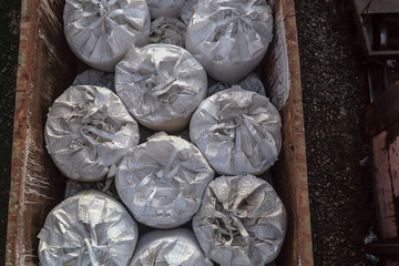 Transportation of  huge white polyethylene bags inside of the wagons by rail. Many containers of...