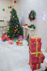 Interior of a New Year's photo studio with a tree.Beautiful Christmas decorated room with Christmas tree with presents under it. Red carpet. Yellow star. New Year's photo studio.