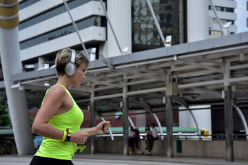 A beautiful, middle-aged woman in shapely exercise clothes And have headphones that listen to music while exercising