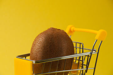 Kiwi on a yellow background in a grocery cart, side view close-up