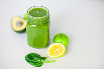  green smoothie in a glass on a table with a green apple and spinach leaves with an apple.detox for a healthy lifestyle, weight loss, ketone diet, raw food diet.