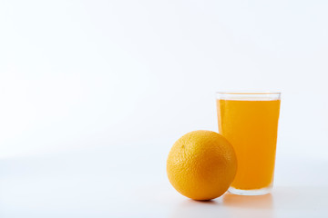 glass of orange juice and orange pieces