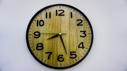 Brown wall clock isolated on white background. Closeup of wood-patterned wall clock. The time is going on concept. Place for text. Copy space. Life is short. Seize the day.	