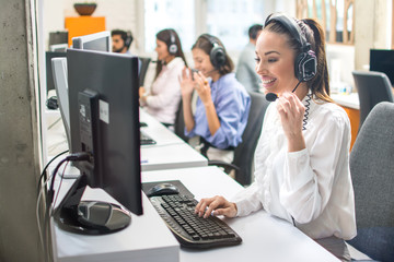 Attractive woman working with customer on hotline support in call center - obrazy, fototapety, plakaty