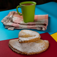 Two delicious robiols, typical Mallorcan baked sweet recipe, traditional in Easter holiday, and a cup of hot chocolate in the background.