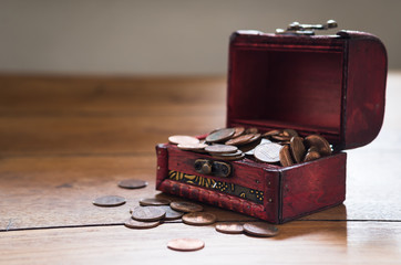 stack of US coins in small wooden chest on the table