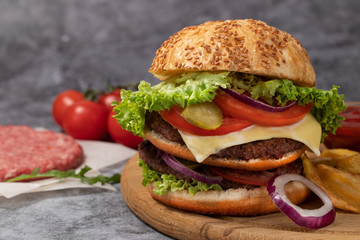 Tasty grilled homemade burgers with beef, tomato, cheese, cucumber and lettuce