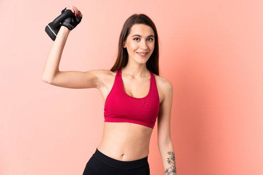 Young sport woman over isolated pink background making weightlifting with kettlebell © luismolinero