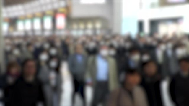 TOKYO, JAPAN - MARCH 2020 : Crowd of people walking at Shinagawa station in morning rush hour. Many commuters going to work. People wearing mask to protect from Coronavirus(COVID-19). Blurred shot.