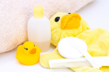 Obraz na płótnie Canvas baby hygiene and bath items, shampoo bottle, baby soap, towel, yellow duck rubber toy, cotton pads and ear sticks, comb.