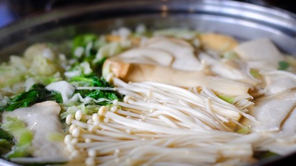 Close up golden needle mushroom Vegetables boiled in hot water , shabu shabu is Korean or Japanese style beef in hot pot dish. delicious food most popular in thailand.