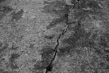 paved road with a crack in black and white