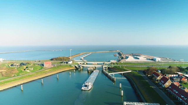 Enclosure Dam (Afsluitdijk): Large Cargo Ship Going Under the Bridge with Traffic to Cross the Dam, Zooming In - Friesland, Netherlands / Holland &ndash; 4K Drone Footage