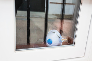 Selective focus of man with a mask confined in quarantine to prevent coronavirus spread to the...