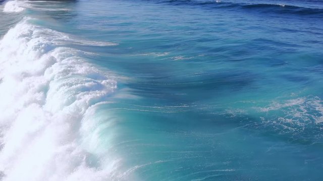 Aerial video of ocean waves at close range. Flying a drone over the waves. A wave hits an ocean reef off the coast of Bali.