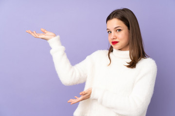 Teenager girl isolated on purple background extending hands to the side for inviting to come