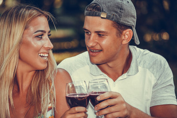 Beautiful  young couple talking, flirting and enjoying a glass of wine on a romantic picnic