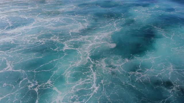 The azure surface of the ocean video from a drone. Texture of the water surface near the shore above the coral reef. Aerial videography of water. Azure sea natural background.