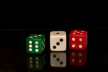 Dice green, white and red on black background