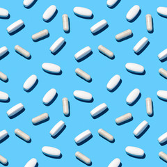 Seamless pills pattern flat lay on light blue.