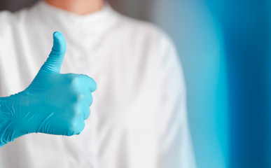 hand gesture of doctor wearing blue gloves, sign for good