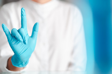 hands gesture of doctor wearing blue gloves, sign for love