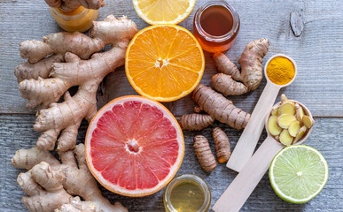 Ginger, turmeric, honey, and various types of citrus fruits cut into slices. Top view on the immune booster. Close up