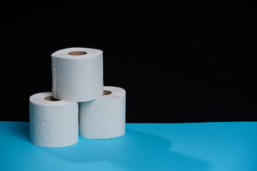 Toilet paper roll. Soft hygienic paper. Black blue background.