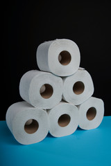 Many toilet paper rolls. Soft hygienic paper. Black blue background.