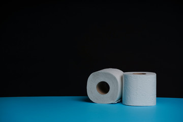 Toilet paper roll. Soft hygienic paper. Black blue background.