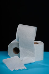 Toilet paper roll on a black blue background. Cheap toilet wipes for hygiene purposes. Soft hygienic paper.
