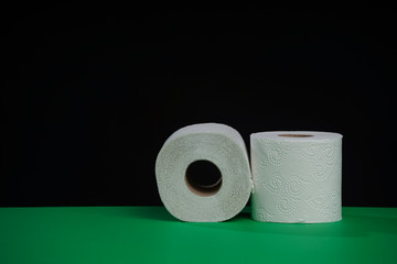 Toilet paper roll. Soft hygienic paper. Black green background.