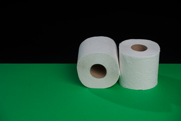Toilet paper roll. Soft hygienic paper. Black green background.