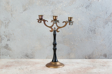 Vintage brass wood candlestick on concrete background.