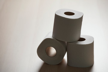 Many toilet paper rolls in a pile. Soft hygienic paper. Wooden table on black background.