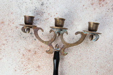 Vintage brass wood candlestick on concrete background.