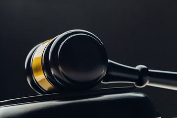 Judge's gavel with gold metal on a black table. Concept of law