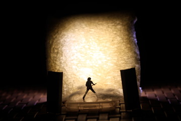 Conceptual Photo, Silhouette Bassist or Guitarist in Action, at Fake Stage, Yellow Lighting