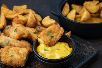 Fast food products: chicken with sauce and potatoes