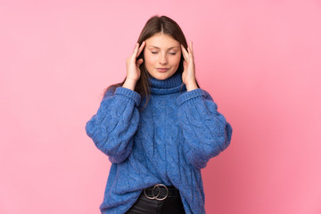 Teenager caucasian girl isolated on pink background with headache